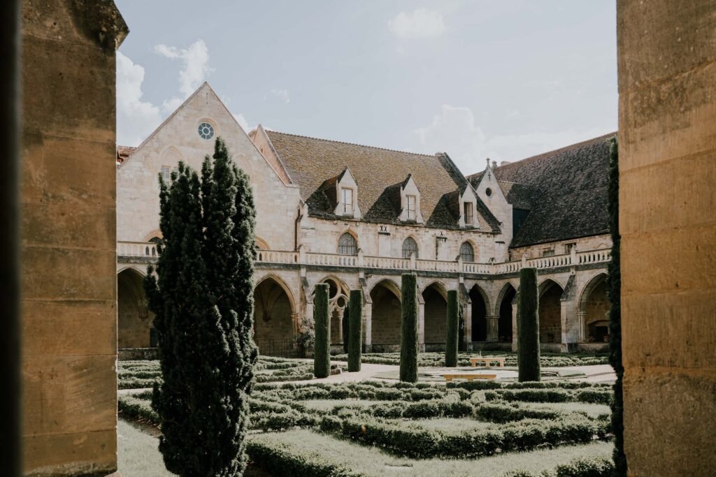 ue du cloître de l'Abbaye de Royaumont, avec ses jardins bien entretenus et ses arches gothiques emblématiques, parfaits pour un mariage en Île-de-France.