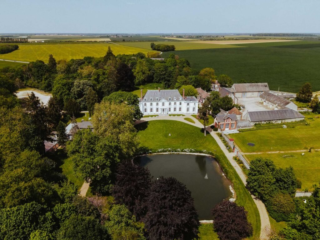 Vue aérienne du domaine du Château Barthélemy entouré de champs et de verdure, un cadre idéal pour un mariage en pleine nature.