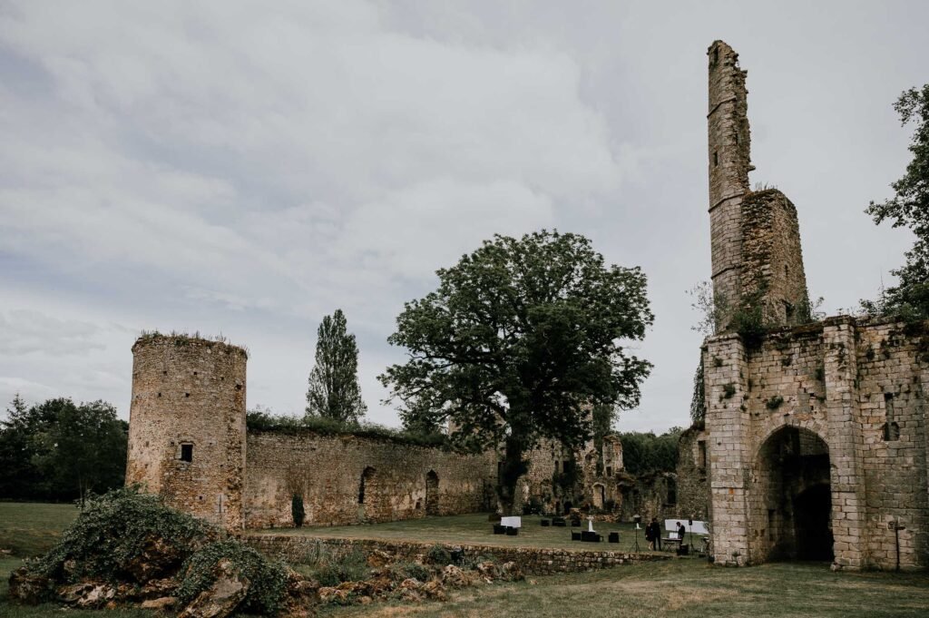 Vue extérieure des ruines du Château de Vivier, entourées de verdure et d'un ciel nuageux, offrant un cadre historique pour un mariage en Île-de-France.