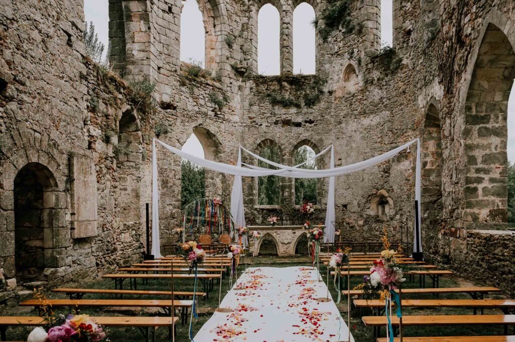 llée fleurie et autel de mariage au sein des ruines du Château de Vivier, créant une ambiance féerique et intime pour un jour spécial.