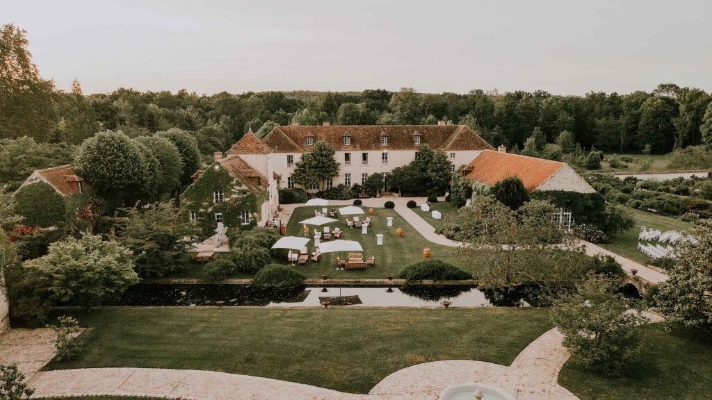 Le Château de Berville au coucher du soleil, avec ses jardins aménagés et ses espaces extérieurs parfaits pour une réception de mariage élégante en Île-de-France.