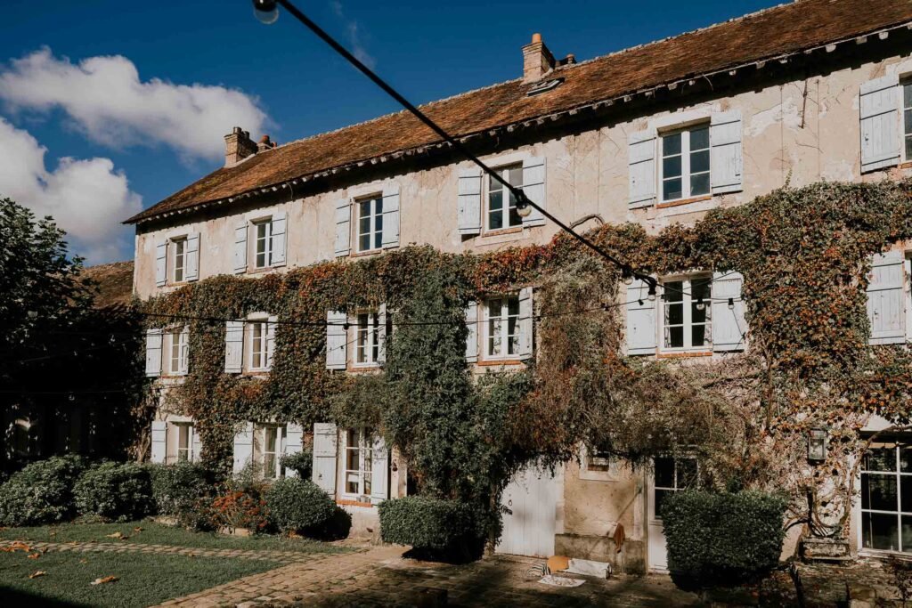 Façade du Moulin de Launoy recouverte de lierre, offrant un cadre chaleureux et pittoresque pour un mariage en Île-de-France