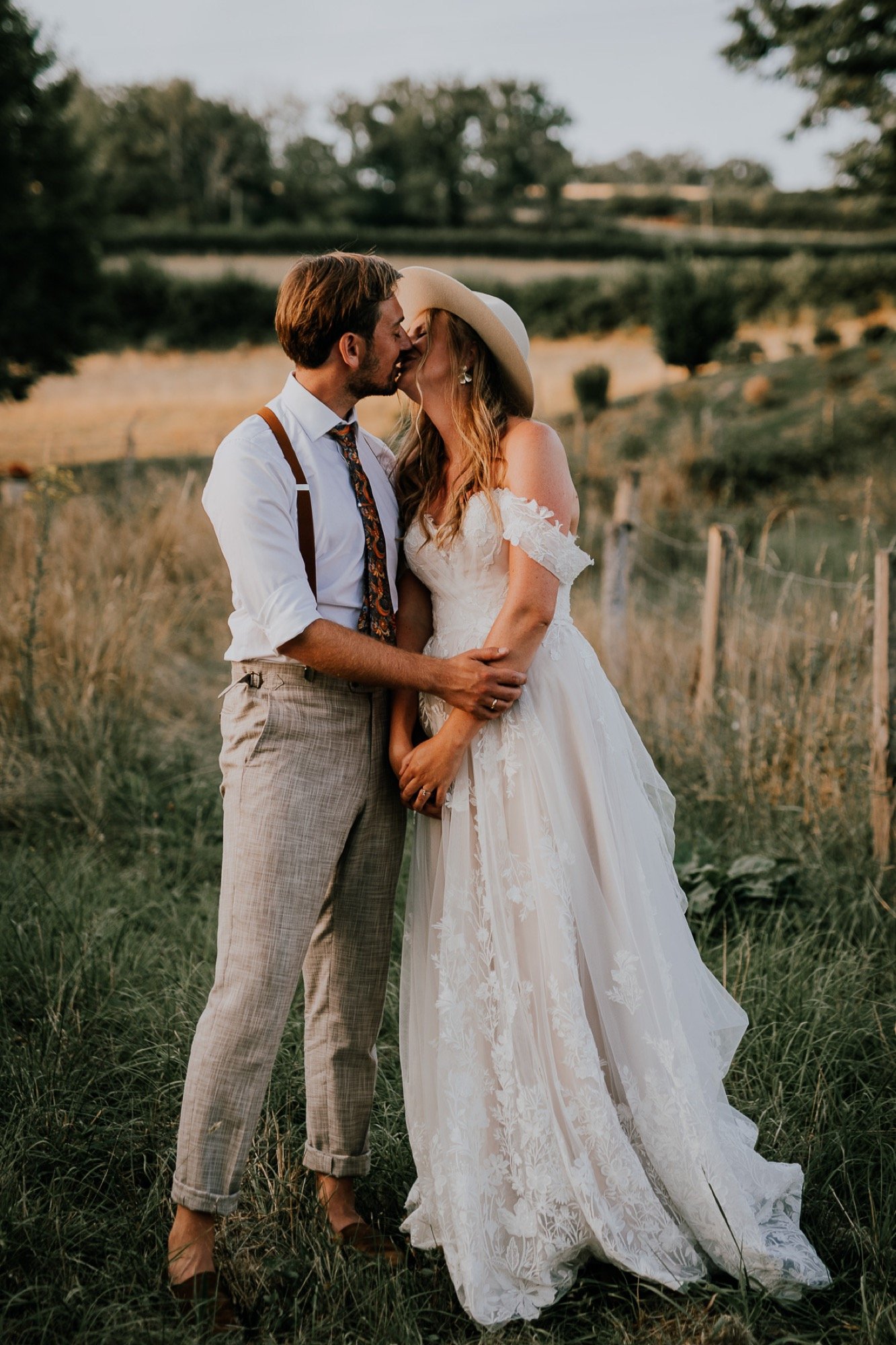 Couple kissing in the French countryside during golden hour.