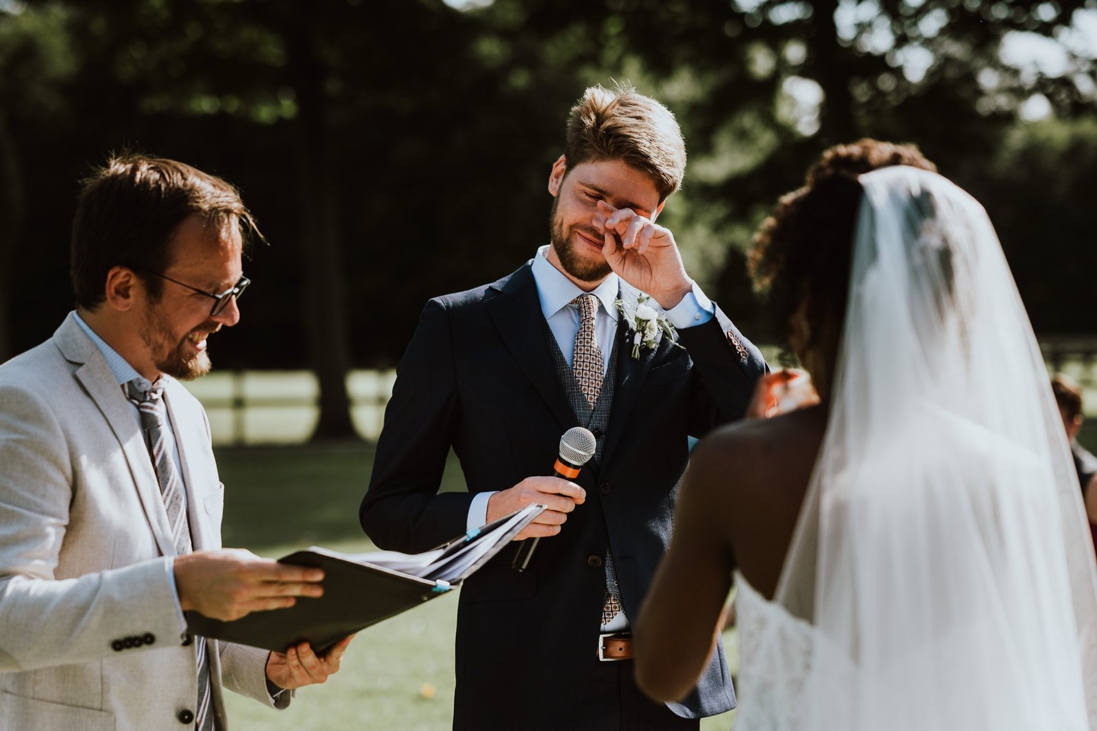 Emotional groom during an outdoor wedding ceremony in France.