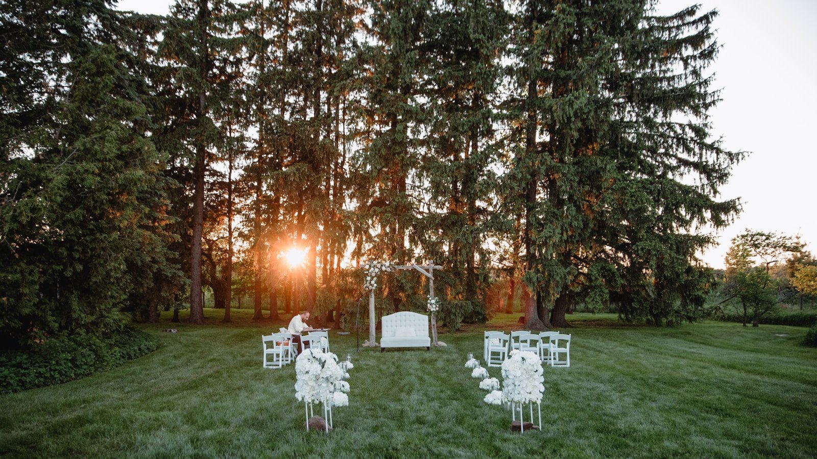 Cérémonie de mariage en extérieur avec chaises en bois et lumière de fin de journée