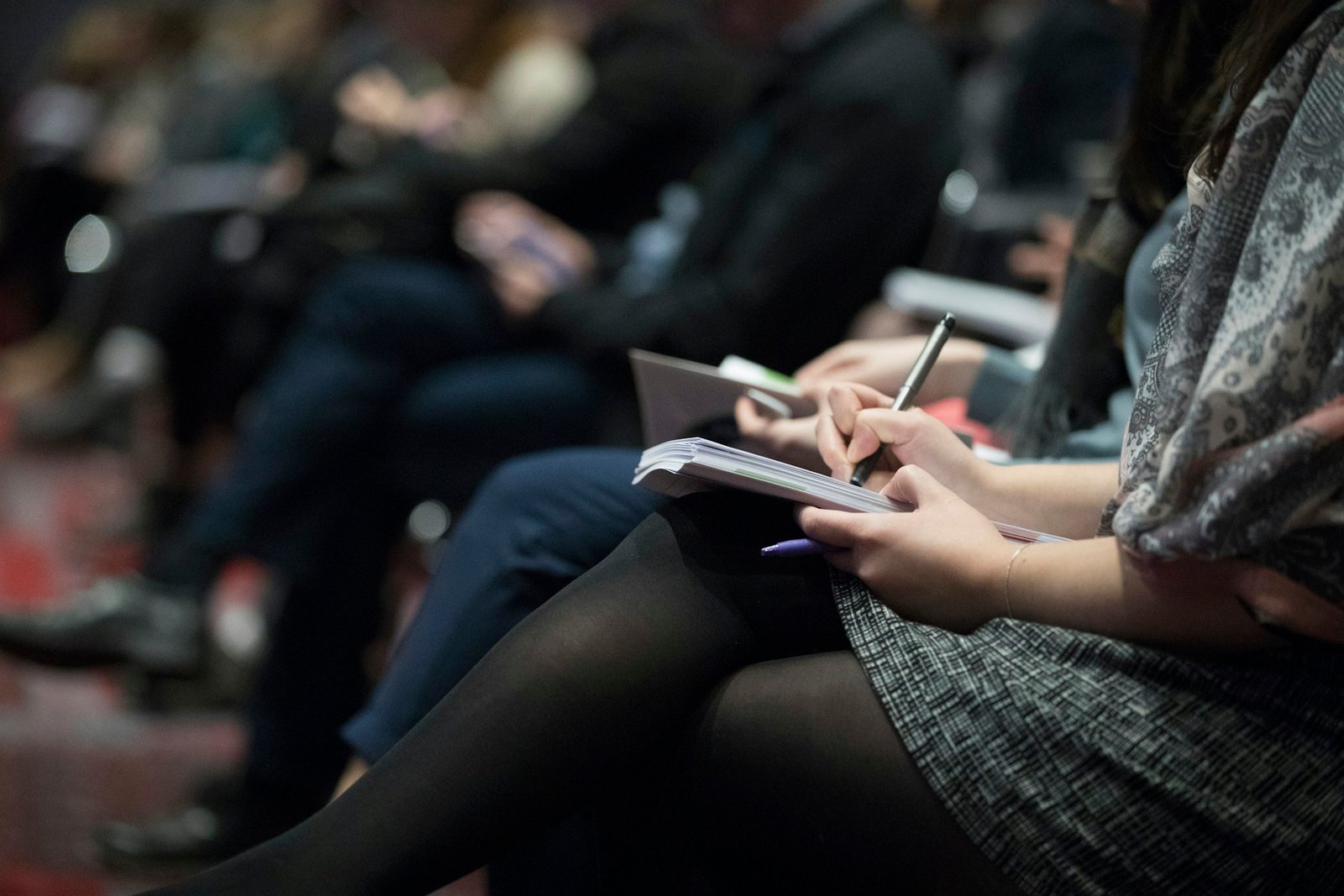 Participante prenant des notes pendant une conférence professionnelle.
