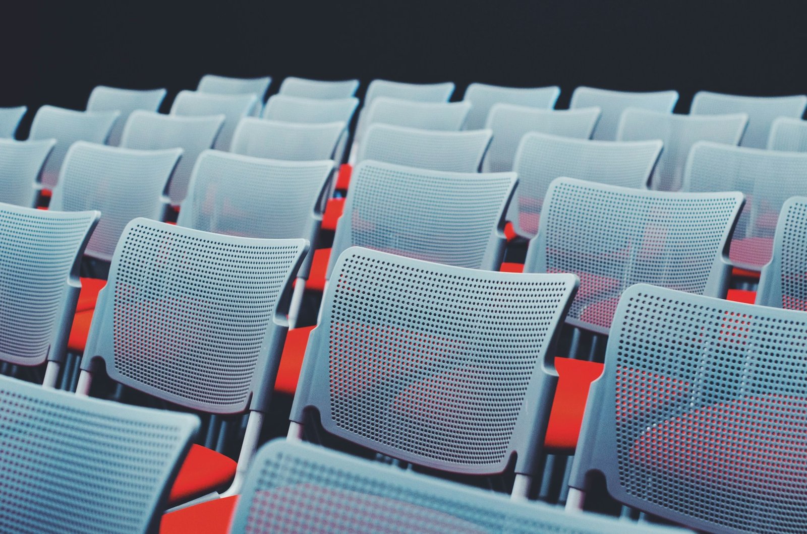 Rangées de chaises installées dans une salle avant un événement.