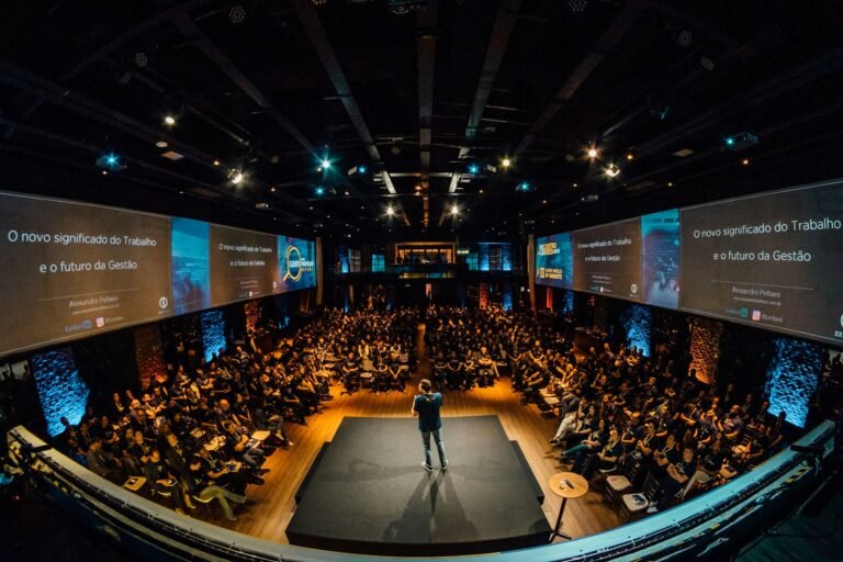 Conférencier s’adressant à un large public lors d’un événement professionnel.